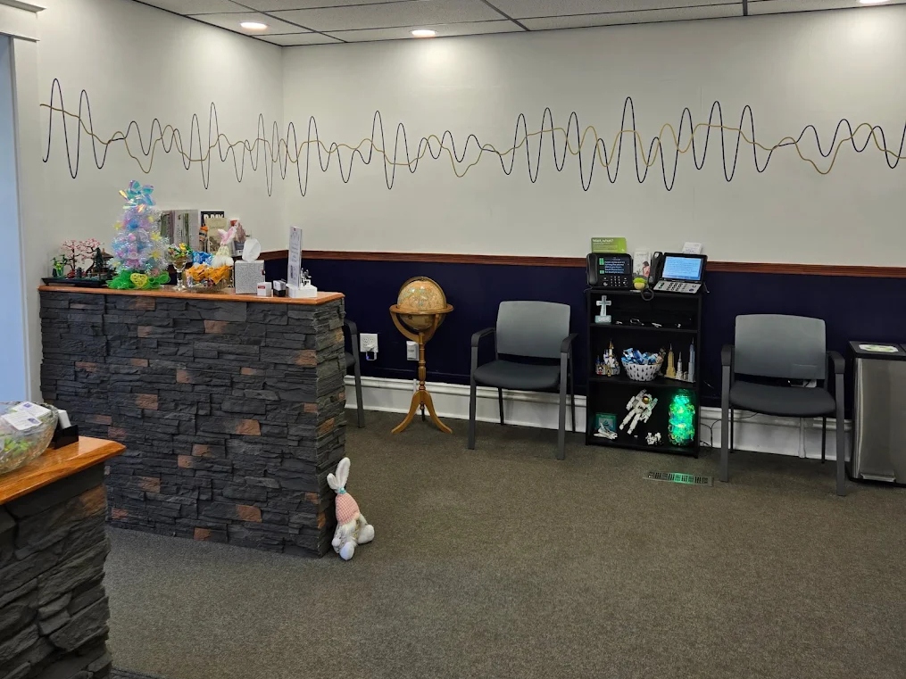 Patient waiting area with sound wave wall art at The Hearing Place in Falconer, NY